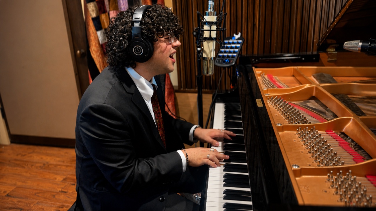 Nico Jones singing and playing grand piano in the studio