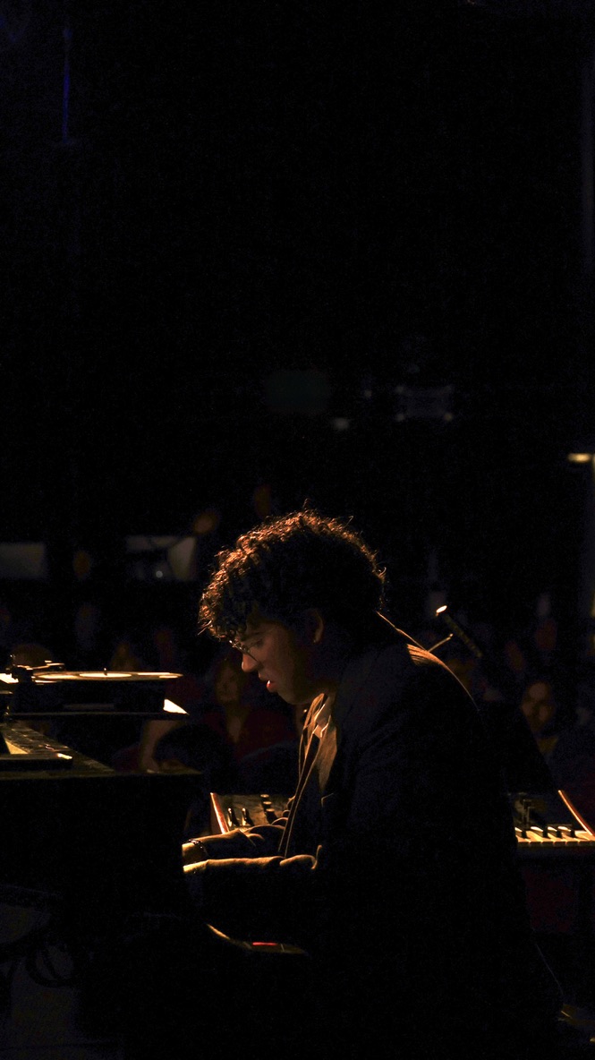 Nico Jones at the piano under stage light